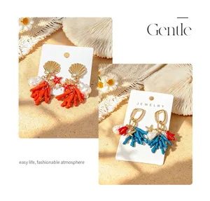 Primer plano detallado de pendientes de coral y concha con estilo de playa tropical.