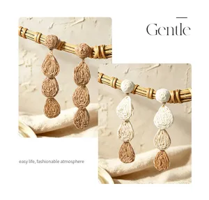 Close-up view of handmade raffia woven drop earrings showcasing delicate texture and details.