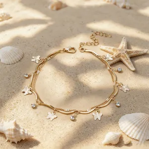 Chaine de cheville papillon double couche dore avec strass sur sable vue principale.