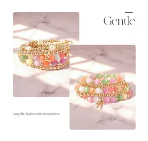 Primo piano del bracciale di perle multistrato con perle occhio di gatto colorate e sfere dorate.