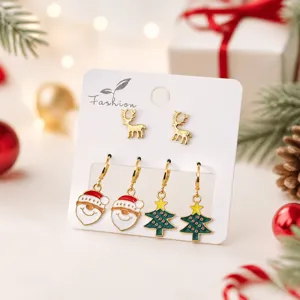 Détail de boucles d'oreilles de Noël avec des rennes et bonhommes de neige pour un look festif.