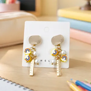 Leuke oorbellen in back-to-school stijl met leuke regenboog wolk en liniaal bedeltjes.