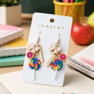 Detailopname van kleurrijke snoep lolly en roze strik hangende oorbellen op displaykaart.