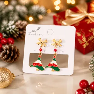 Boucles d'oreilles arbre de Noël avec nœud rouge et pendentif cristal de fête.