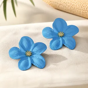 Blaue Blumenohrringe mit goldenem Staubblatt, elegantes Blumen-Detail für modische Accessoires.