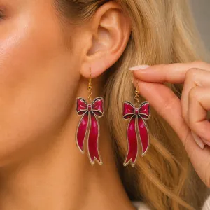 Vista detallada de pendientes de lazo de acrílico rojo, perfectos para fiestas festivas.