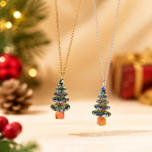 Gros plan détaillé de colliers pendentifs d'arbre de Noël en cristal étincelant or et argent.