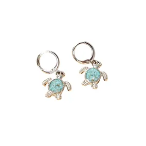 Chic silver turtle hoop earrings with blue stone inlay, perfect for beach vacation styles.