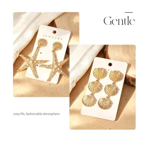 Gros plan détaillé de boucles d'oreilles dorées coquillage et étoile de mer perles.