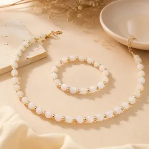 Elegantes Perlenketten und Armband Set in Rosa mit goldenen Akzenten fuer einen schicken Look.