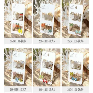 Détail de boucles d'oreilles émail style marin, joli ensemble coquillage et fruit pour plage.