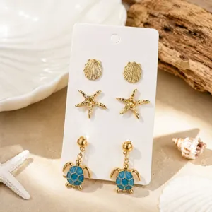 Détail boucles d'oreilles tortue étoile de mer coquillage, ensemble bijoux plage or.