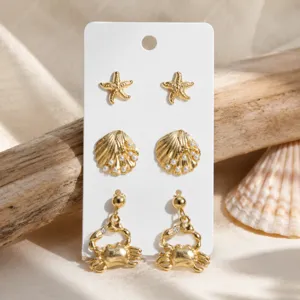 Ensemble de boucles d'oreilles thème océan doré avec coquillage étoile de mer et crabe.