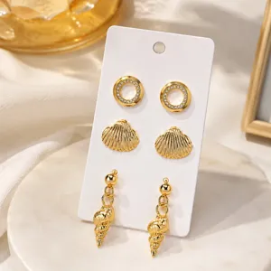 Ensemble de boucles d'oreilles de style marin avec cercles strass et motifs coquillages.