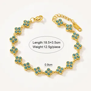 Detail shot of gold-plated stainless steel clover bracelet with blue and white crystal stones.