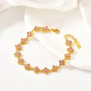 Close-up of luxury gold-plated four-leaf clover crystal bracelet with pink stones.