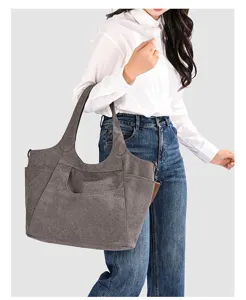 Detailed view of the dark grey canvas shoulder bag showing front pocket and sturdy strap.