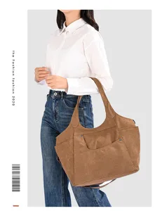 Canvas shoulder bag detail view showing spacious compartment, sturdy handles and front pocket.