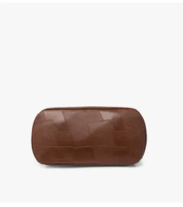 Vue rapprochée détaillée du fond du sac à dos patchwork en cuir synthétique marron.