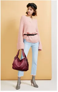 Detailed view of the stylish burgundy leather handbag showcasing soft slouchy design and metal rings.