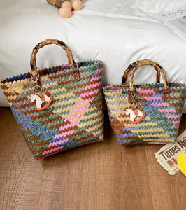 Detailansicht von geflochtenen Strohtaschen mit Bambusgriffen und niedlichen Schaukelpferden.