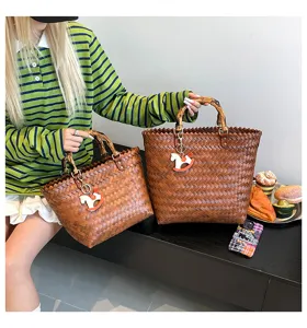 Vintage geflochtene Handtasche mit Bambusgriffen und stilvollem Pferdeanhänger für den Alltag.
