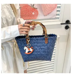 Vintage blaue geflochtene Handtasche mit Bambusgriff und süßem Schaukelpferd Anhänger.