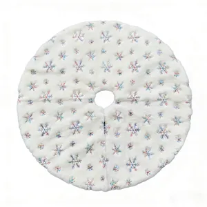 White plush Christmas tree skirt with embroidered colorful snowflakes and sequins for decor.