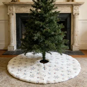 White plush Christmas tree skirt with embroidered snowflakes and shiny sequins for holiday decoration.