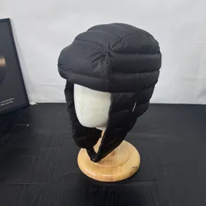 Detail view of black quilted winter earflap trapper hat, warm windproof ski pilot cap.