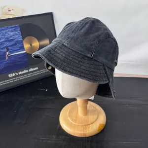 Washed denim bucket hat detail, retro dark grey casual sun hat with brim and side snaps.