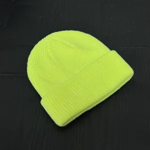 Neon yellow knit beanie detail, close-up shot showing soft ribbed texture and cuffed design.