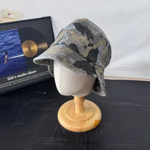 Retro camouflage denim bucket hat detail view, stylish rolled brim outdoor sun cap.