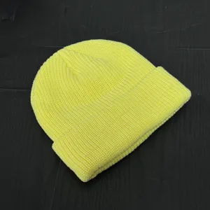 Yellow ribbed knit beanie detail, highlighting soft wool texture and short crown winter style.
