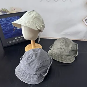 Detail view of retro denim bucket hats featuring wide brims and ear flaps for autumn style.