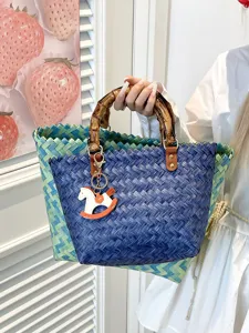 Vintage gewebte Strohkorb Handtasche mit Bambusgriff und süßem Anhänger für den Sommerstrand.