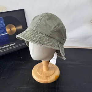 Retro green corduroy bucket hat with ear flaps and metal snaps for autumn and winter outdoor wear.