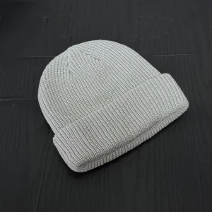 Detailed shot of a casual grey knit beanie, textured ribbed knit design and folded brim.