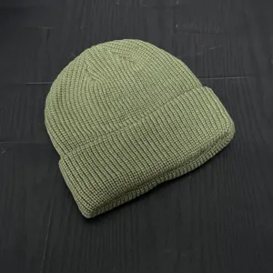 Detailed view of the olive green ribbed knit beanie, showing the fine texture and neat fold.