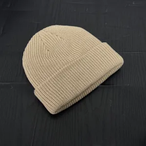 Close-up view of a stylish khaki knitted beanie cap, featuring soft wool texture and fine knit details.
