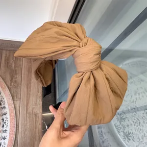 Vue détaillée du serre-tête nœud kaki en tissu plissé, accessoire de coiffure quotidien.
