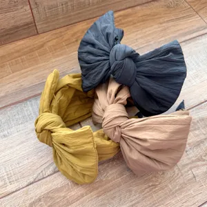 Vue détaillée de serre-têtes tendance avec grands noeuds de couleur unie pour style.