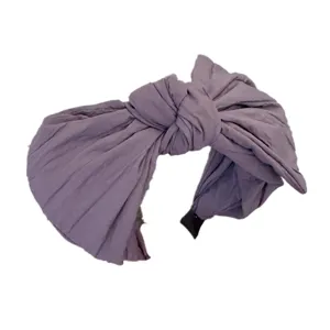 Vue détaillée du serre-tête large unicolore violet à nœud, accessoire de coiffure en tissu.