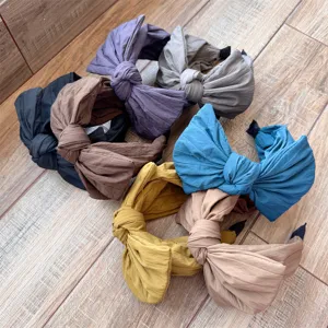 Vue détaillée de plusieurs serre-têtes unicolores avec nœud chic pour le style quotidien.