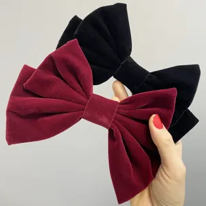Close-up detail shot of elegant double-layer velvet bow hair clips in dual colors.