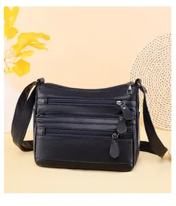 Primer plano del bolso cruzado de cuero suave con múltiples cremalleras y costuras resistentes.