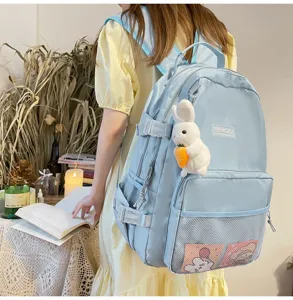 Vista dettagliata dello zaino da studente azzurro con simpatico ciondolo coniglietto e tasche utili.