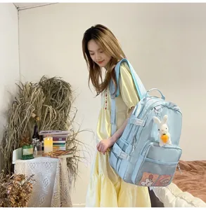 Vista dettagliata di uno zaino casual azzurro con ciondolo in peluche a forma di coniglio.