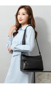 Bolso cruzado negro de cuero suave con múltiples compartimentos con cremallera diario.