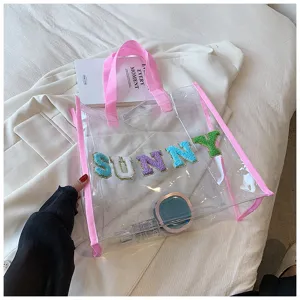 Transparente PVC Strandtasche Shopper mit rosa Riemen und bunten SUNNY Buchstaben Patches.